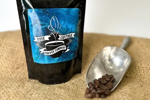 scooped coffee beans and a full Rosebud Cottage coffee bag